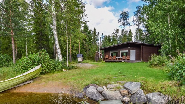 A cabin with a dock extending into a pond, surrounded by dense forest. - Sieralahden lomakylä, mökki 1 by Interhome (Savonlinna)