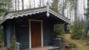 En liten stuga med en trädörr och en veranda.