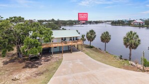 A waterfront property with a covered deck and a view of the water.