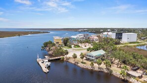 A coastal property with a dock, waterfront houses, and a large building.