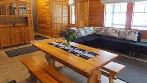 A wooden interior with a wooden table, benches, a sofa, and a cabinet. - Aaretti by Interhome (Padasjoki)