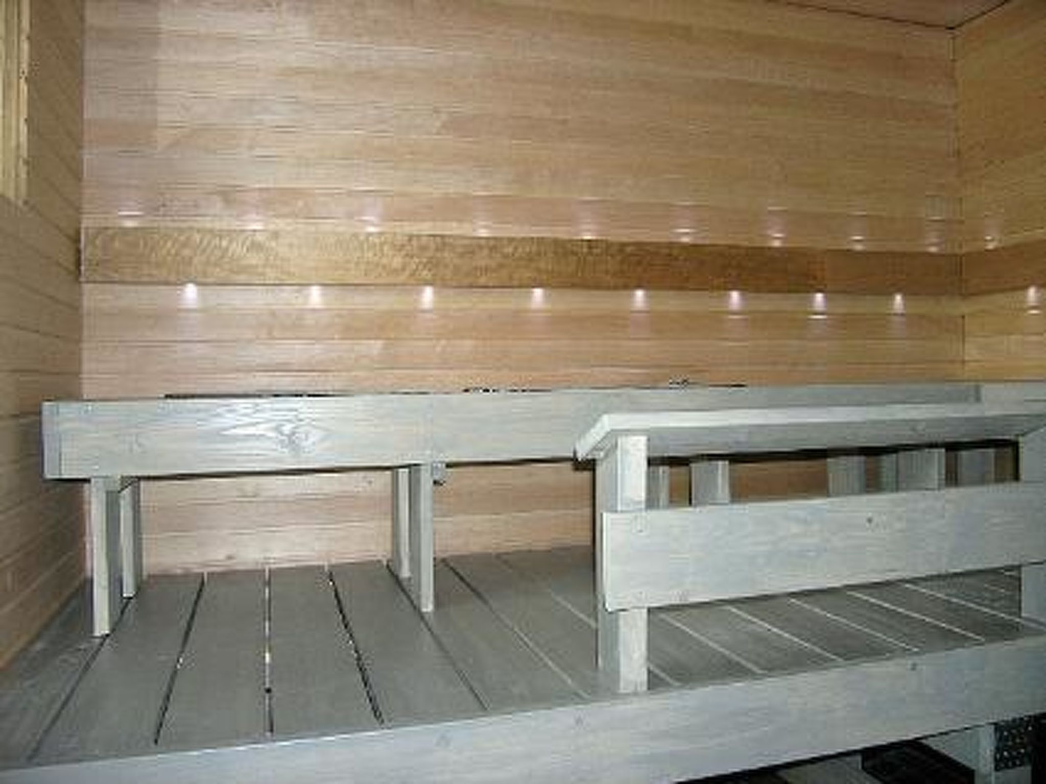 A sauna with wooden benches and a tiled floor.