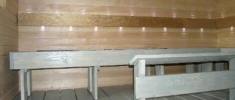 A sauna with wooden benches and a tiled floor.