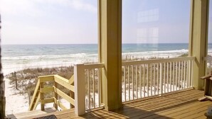 A wooden deck with a view of the ocean and beach.
