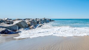 Una playa con rocas grandes y olas.