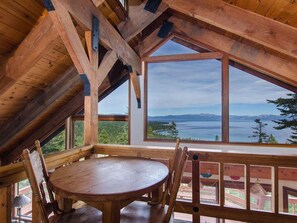 A wooden dining area with a table and chairs, large windows offering a view of a lake and mountains. - Panoramic Lake View, Access Best Tahoe Private Sandy Beach-Buoy Possible Lago Azul By Tahoe Time VR (Tahoma)
