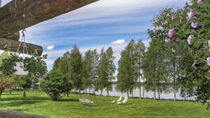 Un espacio verde con un columpio y vistas a un lago.