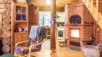 Un intérieur chaleureux avec une chaise en bois, une cheminée et un mur en bois rustique.