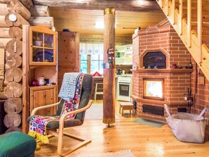 Un intérieur chaleureux avec une chaise en bois, une cheminée et un mur en bois rustique.