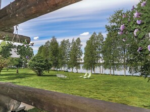 Un espace extérieur verdoyant avec une balançoire, un banc et une vue sur un lac.