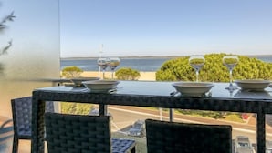 A table with wine glasses and bowls, overlooking a beach and ocean. - Apartment Claire by Interhome (Arcachon)