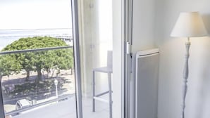 A balcony with a view of the sea, a chair, a lamp, and a radiator. - Apartment Claire by Interhome (Arcachon)