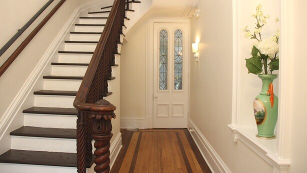A staircase with wooden handrails and white walls. - Governor's Mansion Inn (Madison)