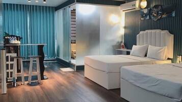 A modern bedroom with a large bed, a desk, and a stool.