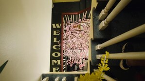 Una escalera con un cartel de 'WELCOME' y flores de cerezo.