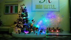 Un árbol de Navidad decorado y un letrero que indica MIO HOTEL.