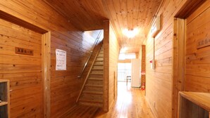 Un intérieur en bois avec un escalier menant à un espace plus lumineux.