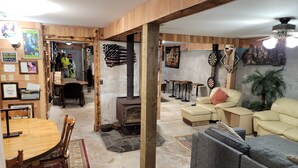 Ein gemütliches Wohnzimmer mit Kamin, Ledersofas und einem Essbereich mit Holztisch und Stühlen.