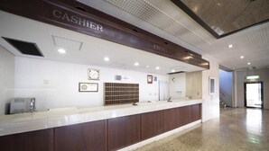 A hotel reception area with a counter, a clock, framed certificates, and a reception desk. - Hisai Green Hotel (Tsu)