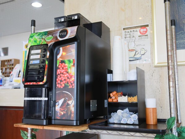 Una cafetera con pantalla digital y una taza de café.