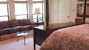 Une chambre à coucher avec un lit à baldaquin, un canapé et une petite table.