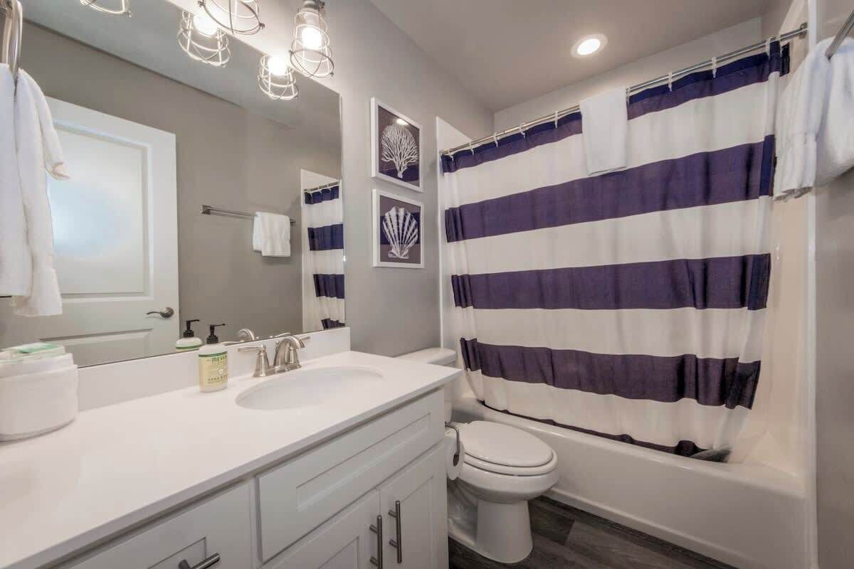 A modern bathroom with a white sink, a toilet, and a bathtub.