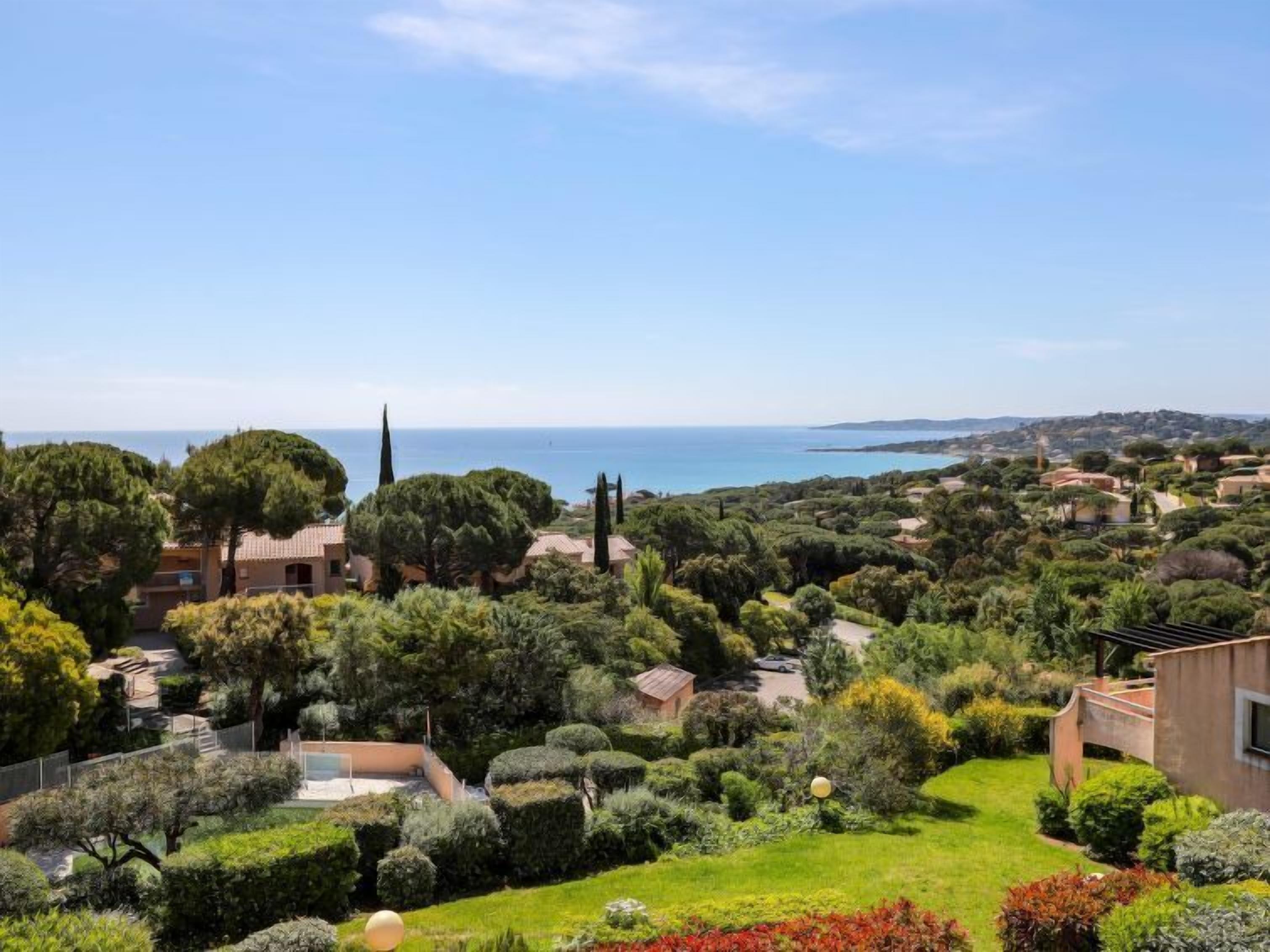 Una propiedad costera con vistas al mar, rodeada de vegetación exuberante y jardines cuidados.