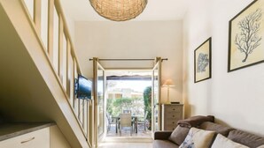A modern living room with a sofa, TV, and artwork. - Mas de la Plage by Interhome (Cavalaire)