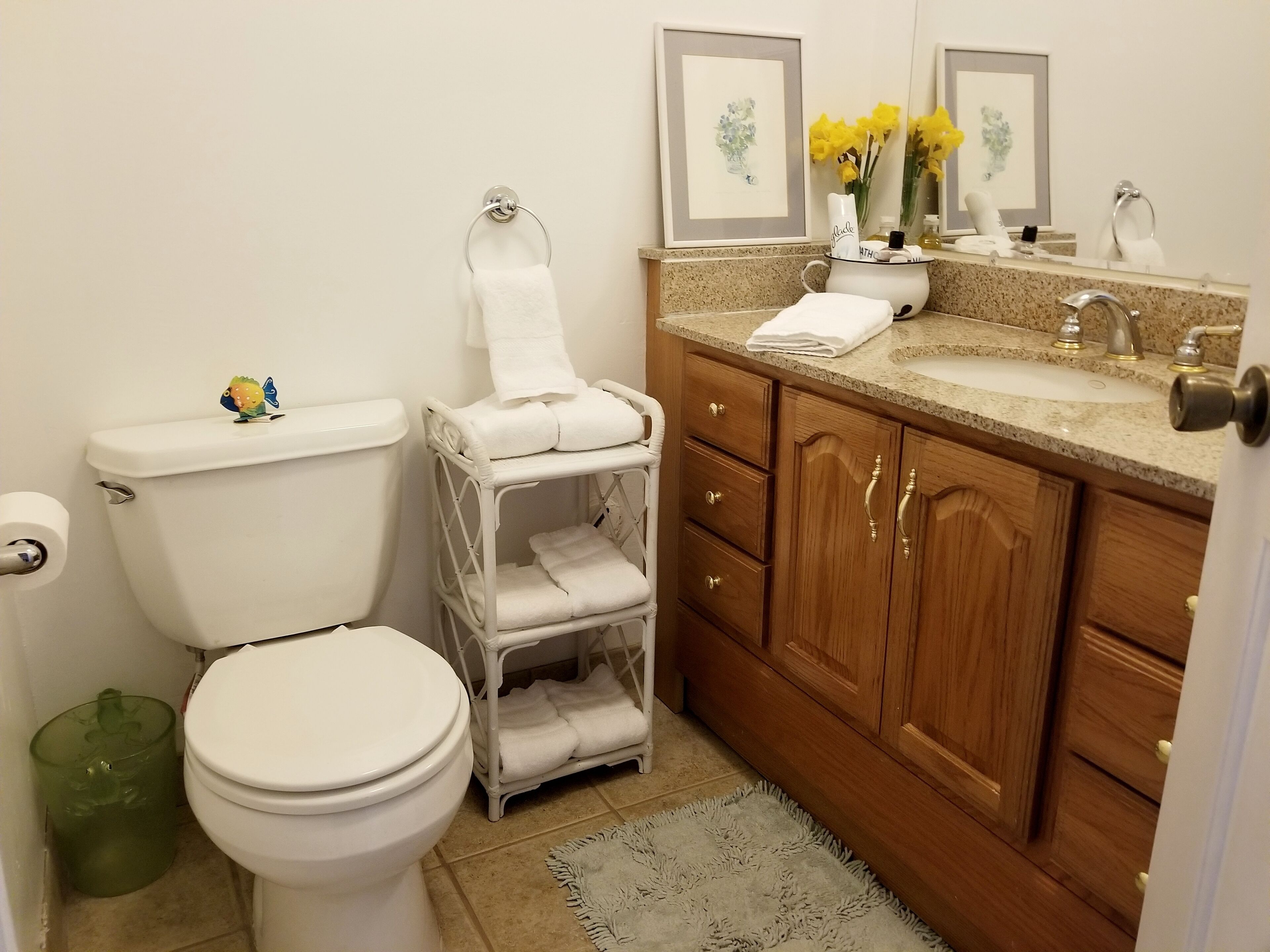 A bathroom with a toilet, a sink, and a vanity with a mirror.