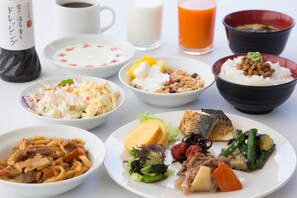 Verschiedene Gerichte, darunter Reis, Nudeln und Gemüse, was auf eine Mahlzeit hindeutet.