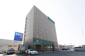Un hôtel à plusieurs étages, reconnaissable à son grand panneau situé en haut de la façade.