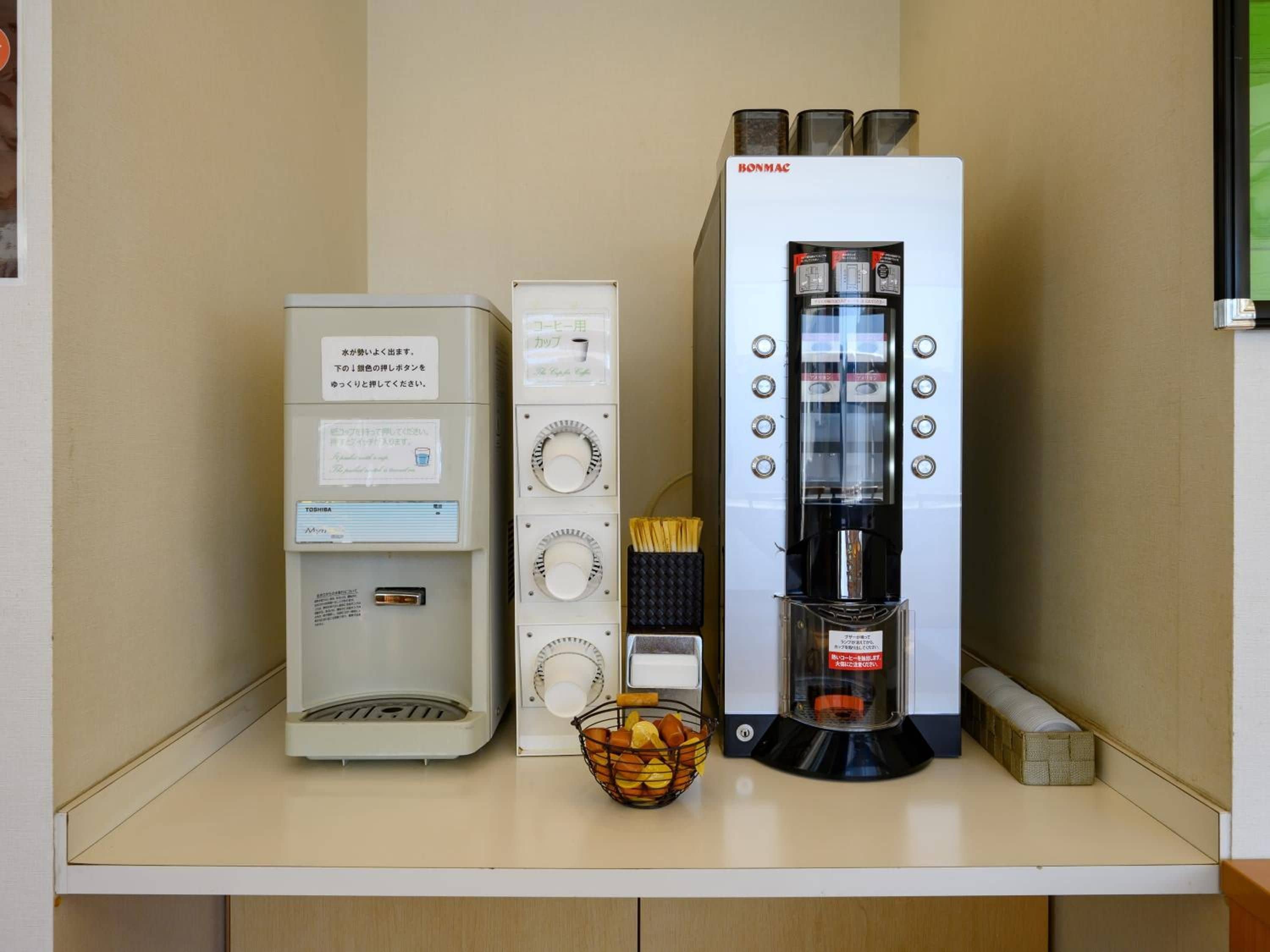A kitchenette with a coffee machine, a rice cooker, and a small refrigerator.