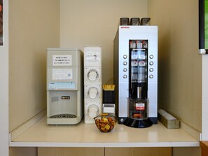 Une petite cuisine équipée d’une machine à café, d’un cuiseur à riz et d’un petit réfrigérateur.