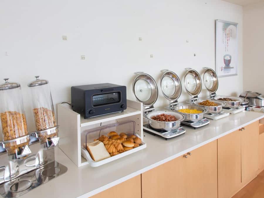 Een buffetopstelling met diverse gerechten en een magnetron.