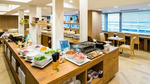 A buffet-style restaurant with a variety of dishes, a grill station, and seating areas. - Super Hotel Ikebukuro-Eki Kitaguchi (Tokyo)