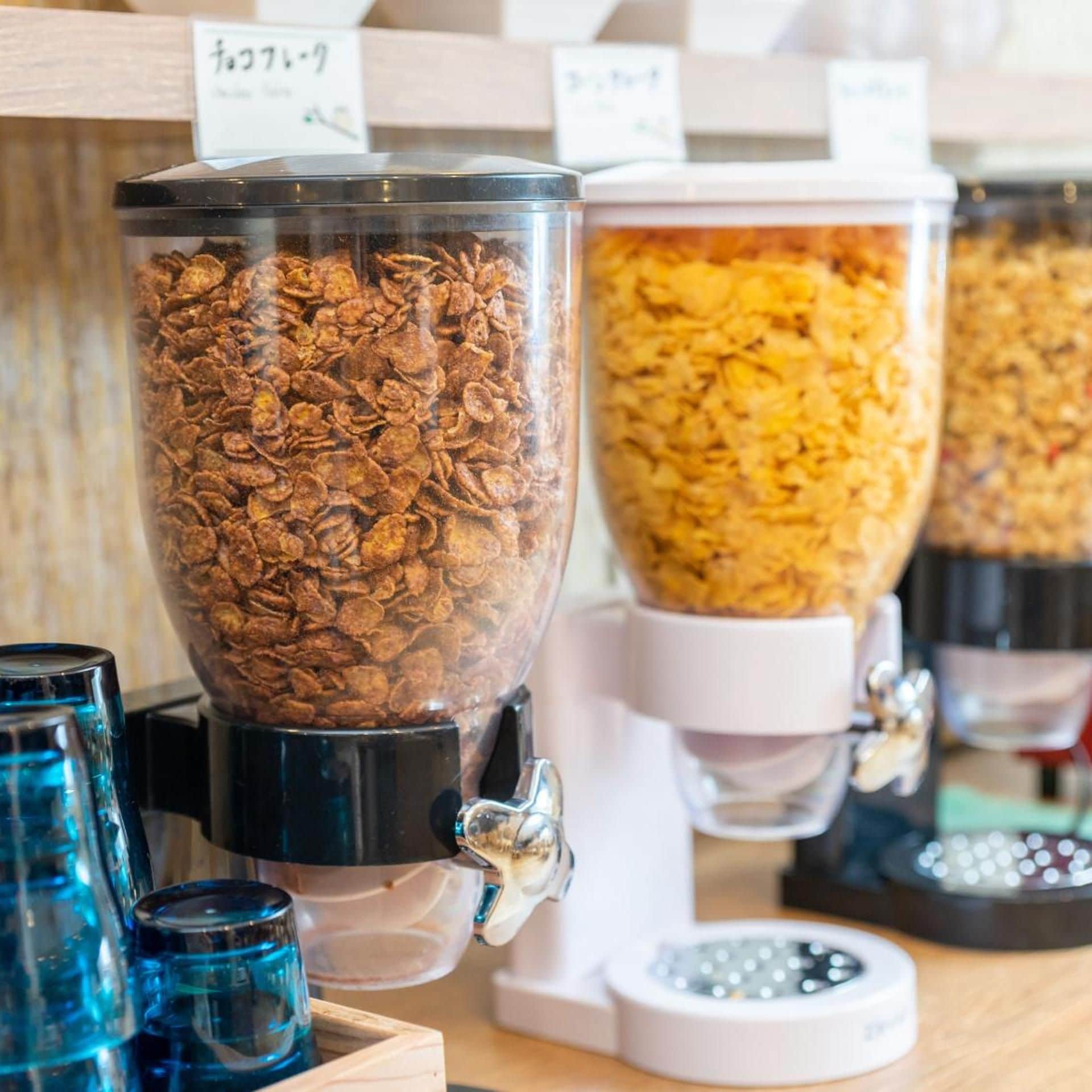 Uma área de preparação de alimentos com grandes recipientes cheios de flocos de cereais.