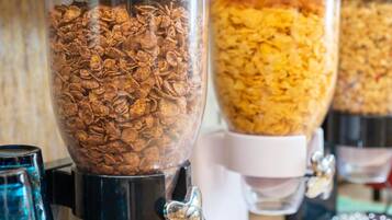 Uma área de preparação de alimentos com grandes recipientes cheios de flocos de cereais.
