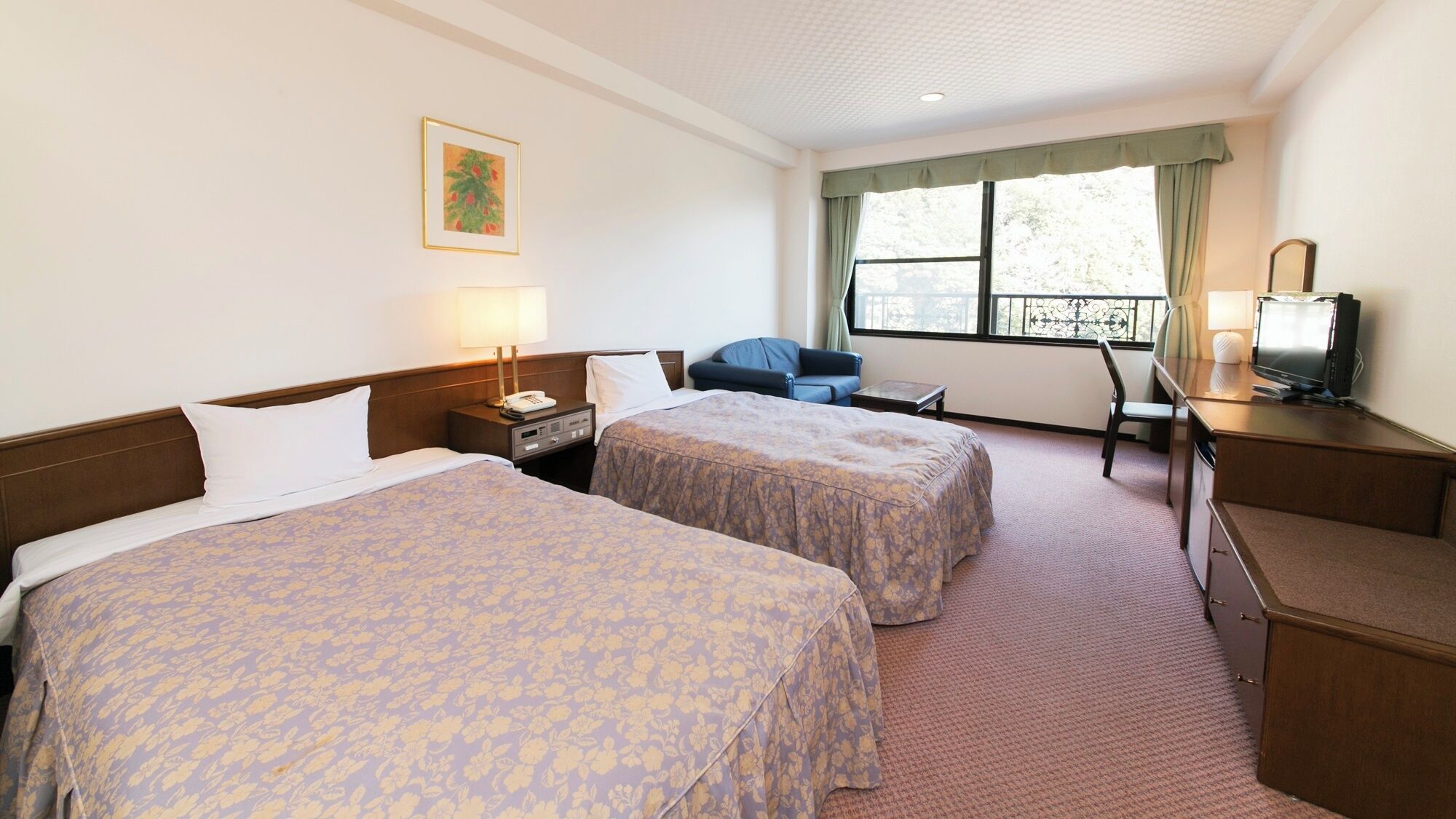A hotel room with two beds, a desk, a chair, a television, and a window with curtains.