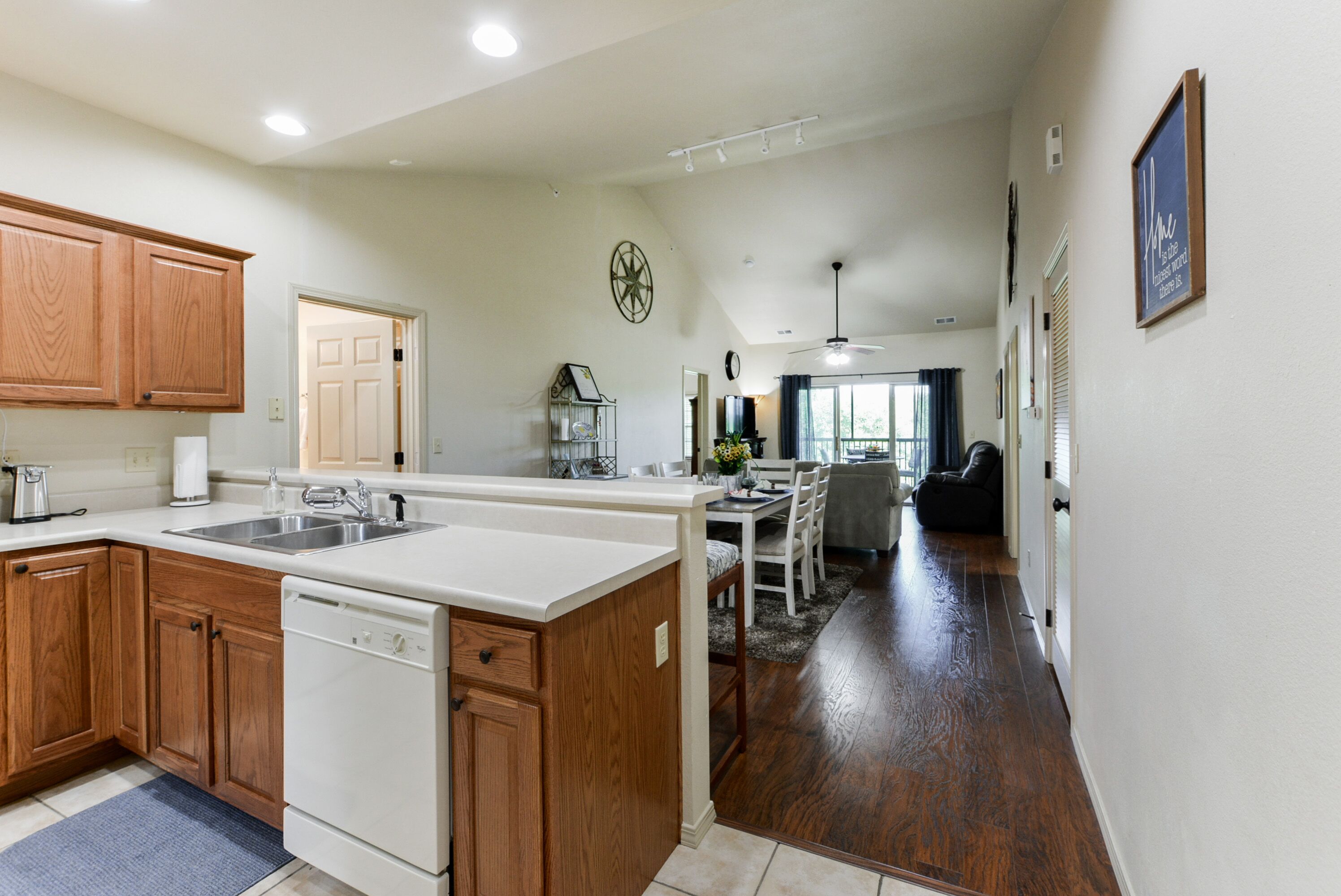 A spacious kitchen with wooden cabinets, a dishwasher, and a central island.