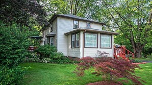 A two-story house with a front porch and a small garden. - 4 Bedroom Home Near Warren Dunes State Park (Sawyer)