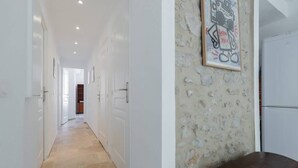 Passadís amb parets blanques, una paret d'accent de pedra i un quadre encimbellat.
