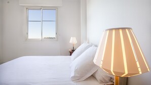 A bedroom with a bed, a window, and a lamp. - Bright, 63m², panoramic view of city and sea. Garage (Cannes)