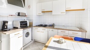 A compact kitchen with a washing machine, a toaster, and a sink. - Bright, 63m², panoramic view of city and sea. Garage (Cannes)
