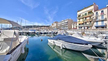 Boats docked in a tranquil marina, surrounded by buildings with waterfront views.