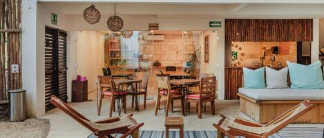 A cozy interior with wooden furniture, a seating area, and a kitchen visible through a glass partition.