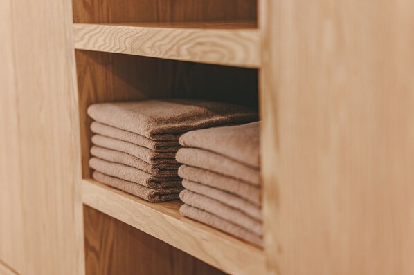 A wooden shelf with neatly folded towels. - Mayan Monkey Tulum | Social Hotel (Tulum)