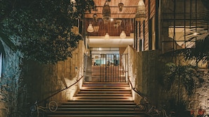 A staircase with a metal railing, wooden steps, and hanging light fixtures. - Mayan Monkey Tulum | Social Hotel (Tulum)