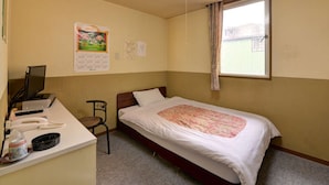 A small, single-bed room with a desk, chair, and a window with curtains. - Hotel Million (Muroran)