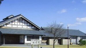 A traditional Japanese building with a sloped roof and a sign in front. - Ryori Ryokan Jukoen (Echizen)