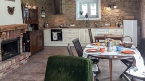 A rustic kitchen with a stone wall, wooden beams, and a fireplace. - Dom na Skraju by Interhome (Lubomierz/Gryfow Slaski)